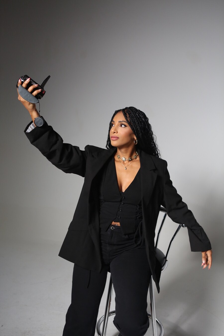 Cennet holding a camera in a studio